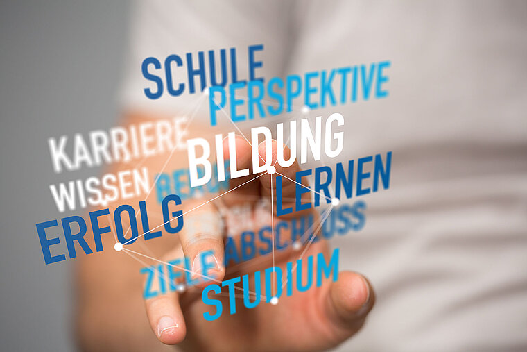 Begriffe wie Bildung und Studium im Vordergrund, während eine Person im Hintergrund nach den Begriffen greift.