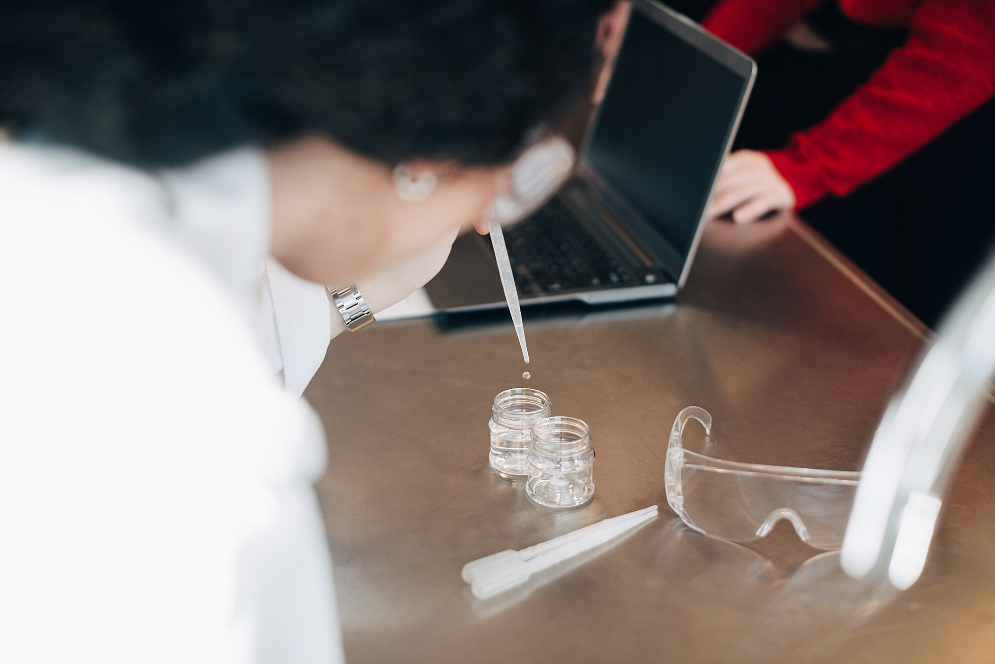 Chemikanten, die mit einer Pipette ein Reagenzglas befüllen