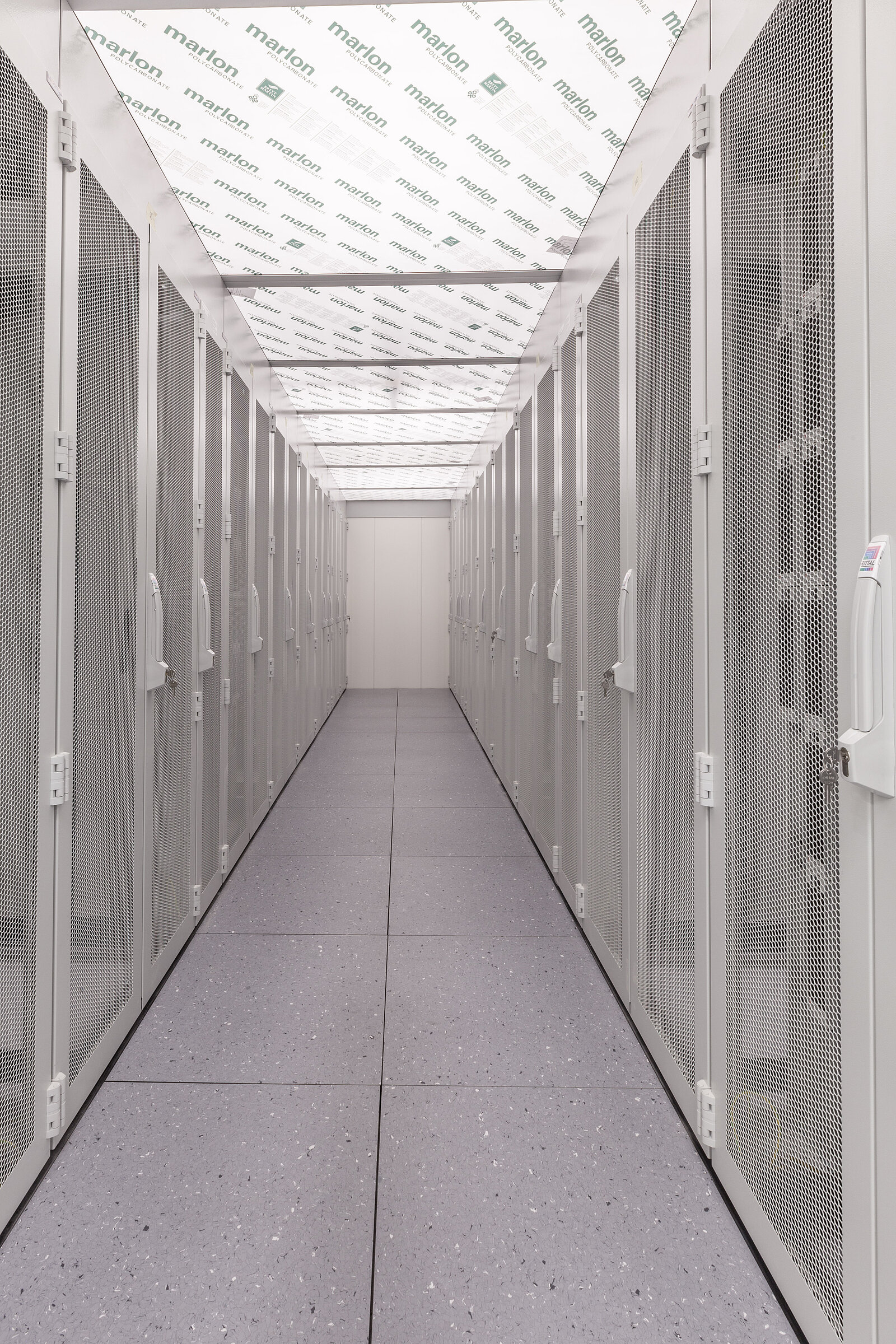 Servergang, links und rechts daneben Serverschränke in weiß