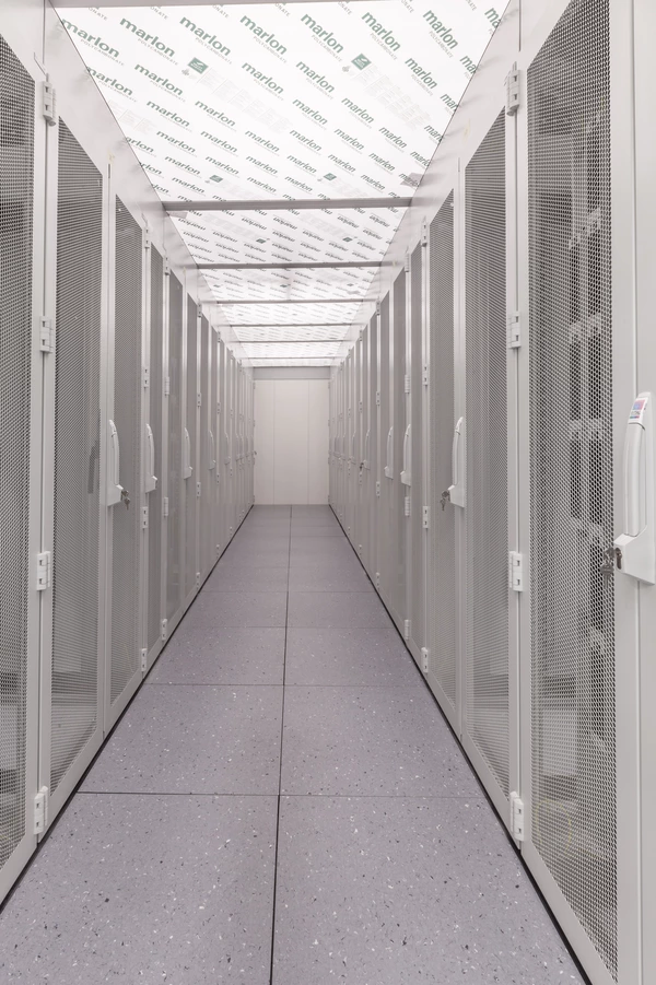 Servergang, links und rechts daneben Serverschränke in weiß