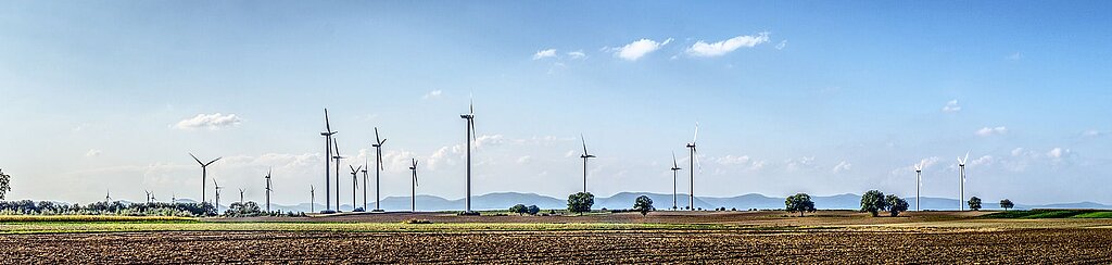 diverse Windräder auf einem Feld