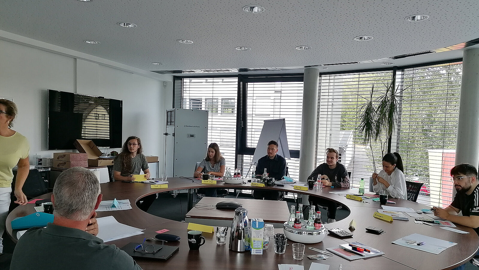Azubis und Mitarbeiter in einem Seminar auf bei der Arbeit an einem runden Tisch