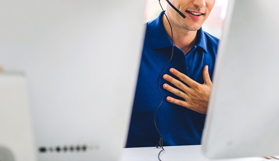 Mann mit Headset redet, daneben 2 weiße Monitore