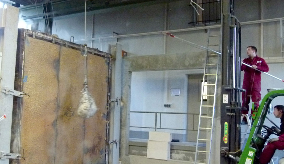 Exam container on the left, on the right a man with a long stick and a man in a forklift truck