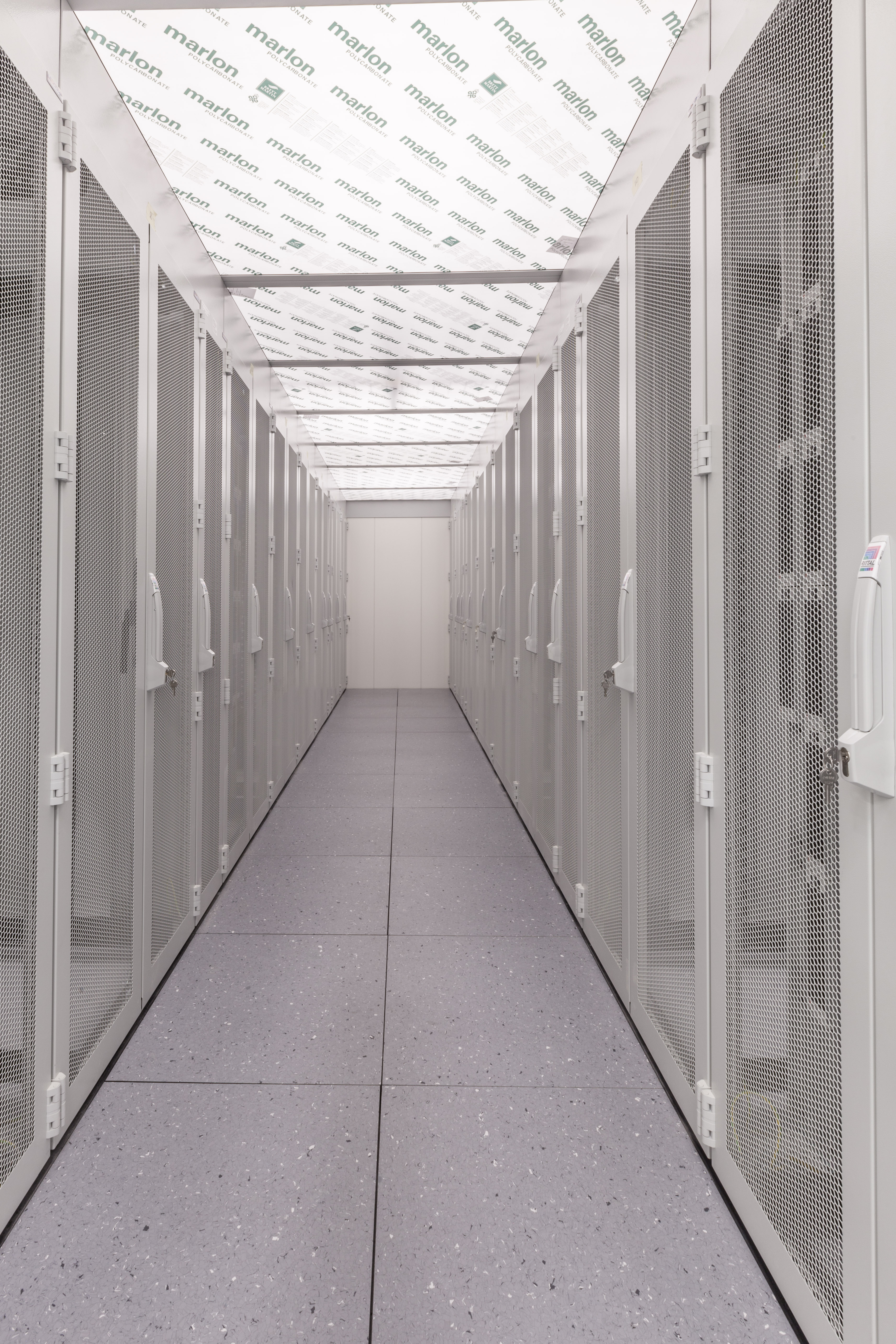 Servergang, links und rechts daneben Serverschränke in weiß