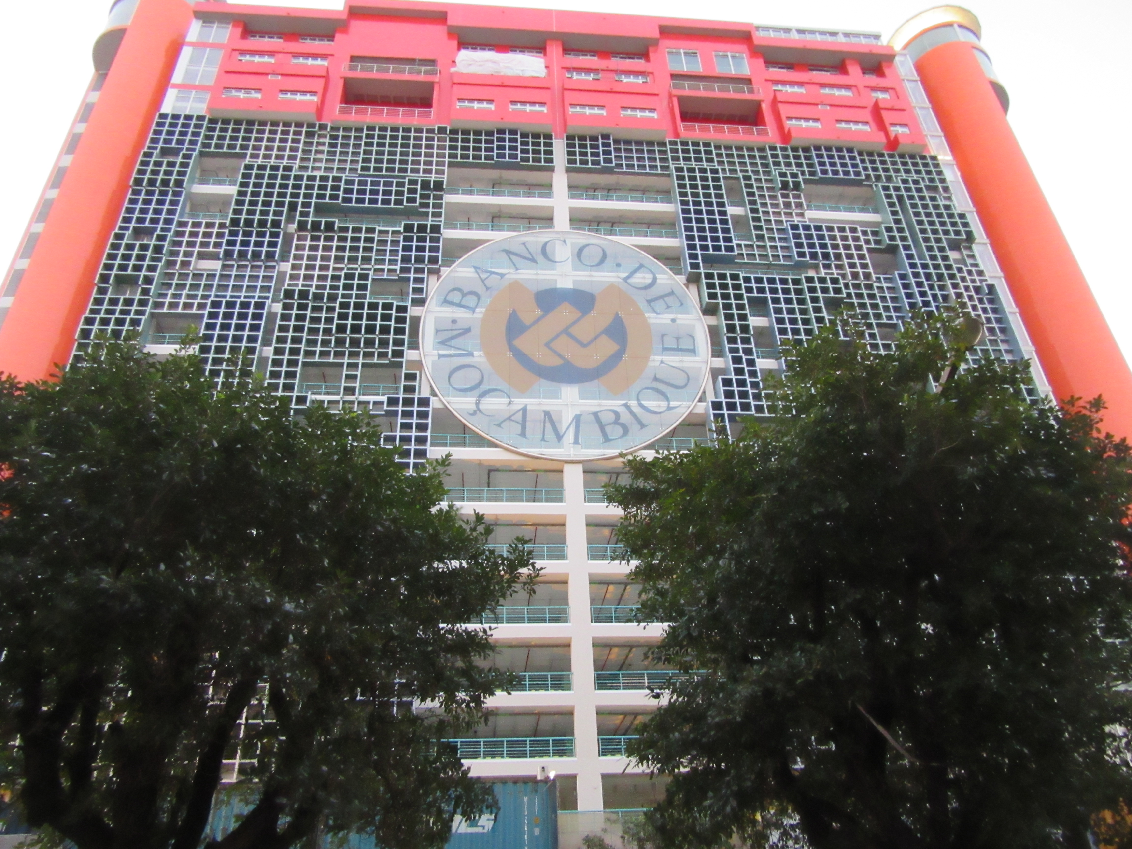 Gebäude der Bank de Maosambik mit Logo in der Mitte und 2 Bäumen links und rechts unten